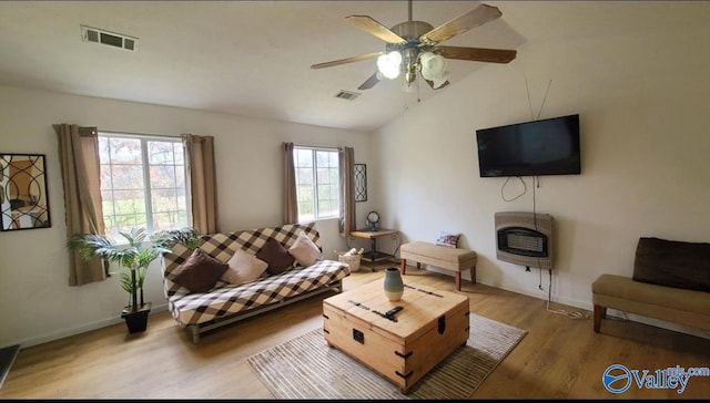 living room with hardwood / wood-style flooring, ceiling fan, lofted ceiling, and heating unit