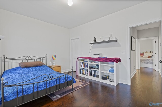 bedroom with dark hardwood / wood-style flooring