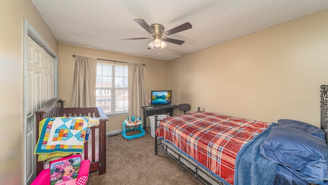 carpeted bedroom featuring ceiling fan, baseboards, a closet, and a textured ceiling