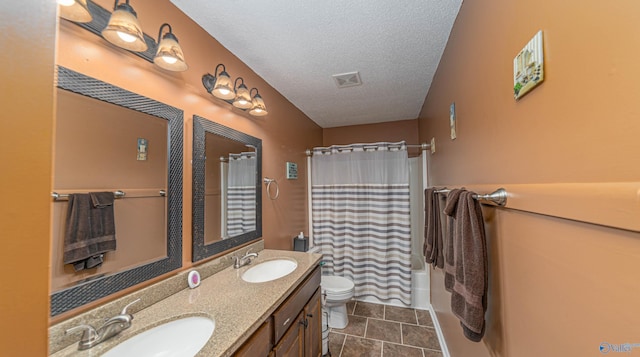 full bathroom featuring visible vents, a textured ceiling, toilet, and a sink