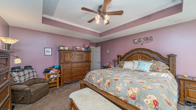 carpeted bedroom featuring ceiling fan, a tray ceiling, a textured ceiling, and ornamental molding