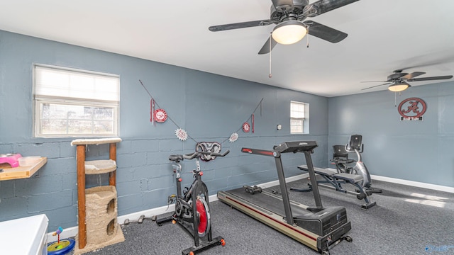 exercise room with baseboards and concrete block wall