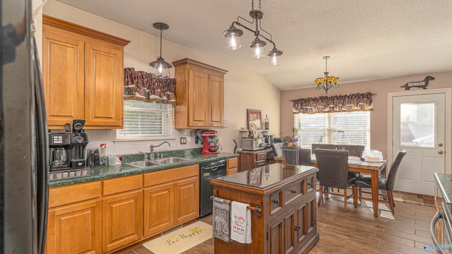 kitchen featuring a sink, dark countertops, black appliances, and a wealth of natural light