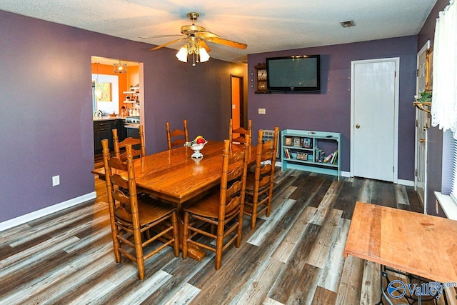 dining room with a textured ceiling, dark hardwood / wood-style floors, and ceiling fan