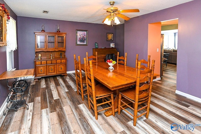 dining room featuring a textured ceiling, dark hardwood / wood-style flooring, and ceiling fan