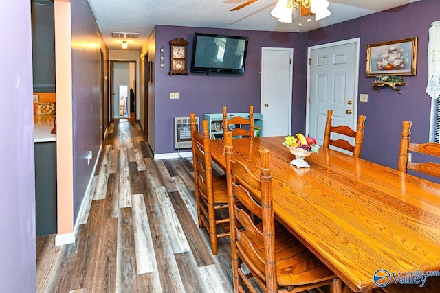 dining space featuring ceiling fan, heating unit, and wood-type flooring