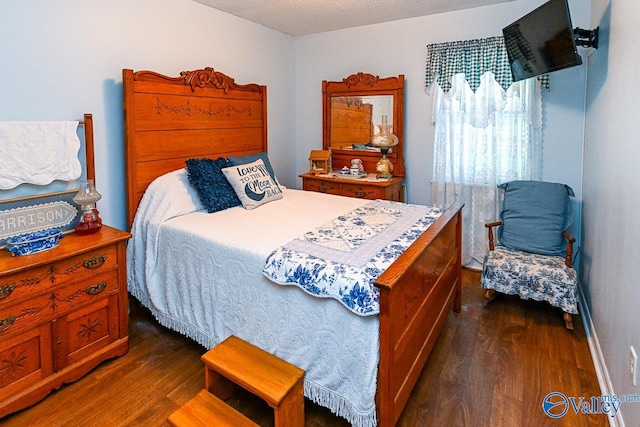 bedroom featuring a textured ceiling and dark wood-type flooring