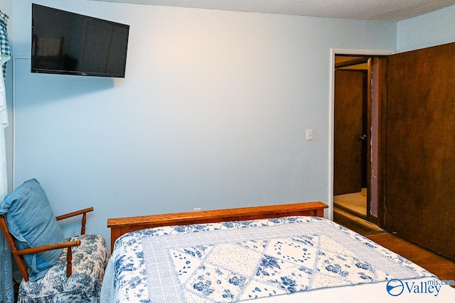 bedroom featuring a textured ceiling and dark hardwood / wood-style floors