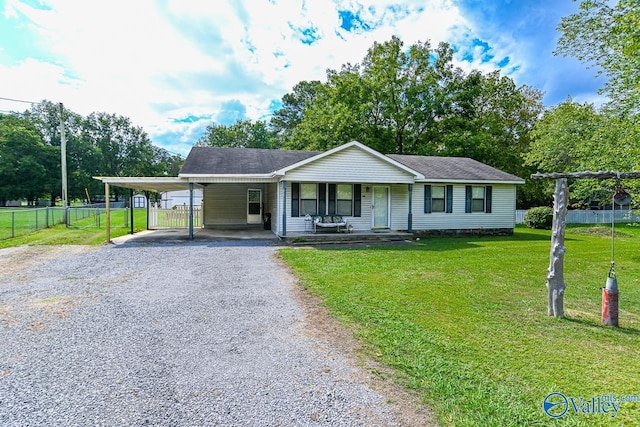 ranch-style home featuring a front yard, covered porch, and a carport