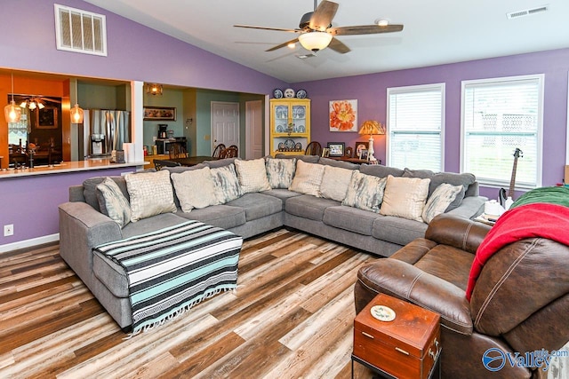 living room featuring vaulted ceiling, ceiling fan, and hardwood / wood-style flooring