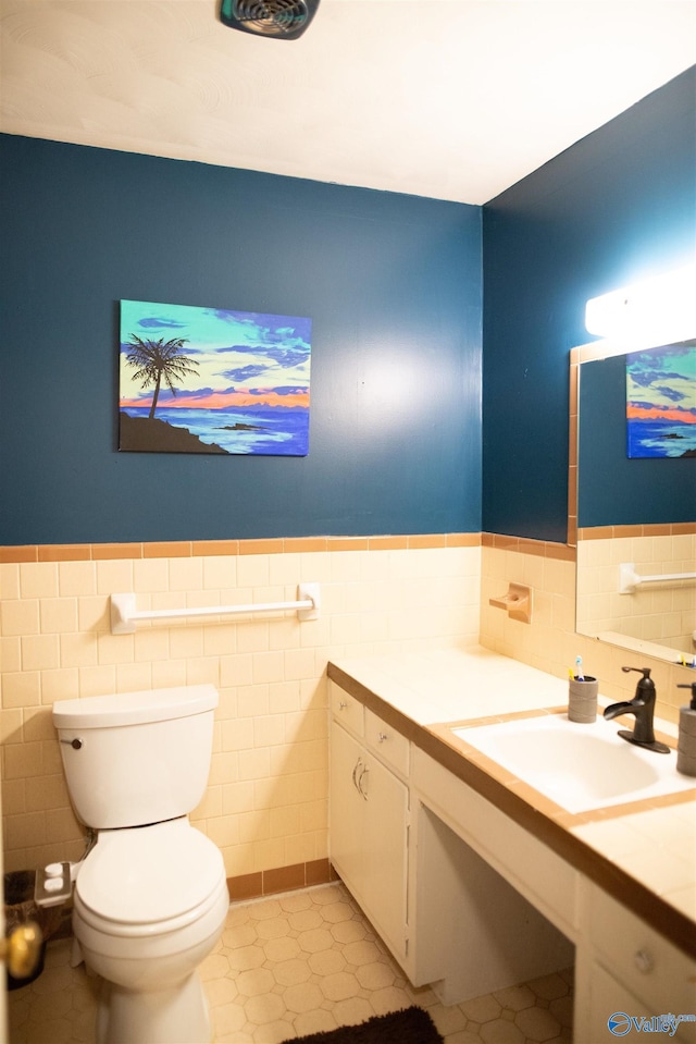 1709 Iris SW, Decatur, AL 35601 - bathroom with tile walls, vanity, toilet, a wainscoted wall, and tile patterned floors