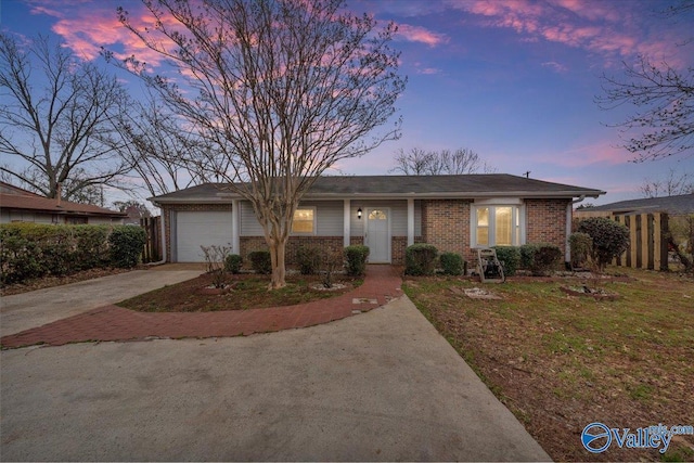 single story home with a garage, brick siding, driveway, and fence