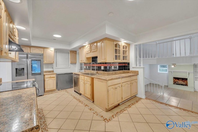 kitchen with a tray ceiling, light tile patterned floors, light brown cabinetry, and a sink