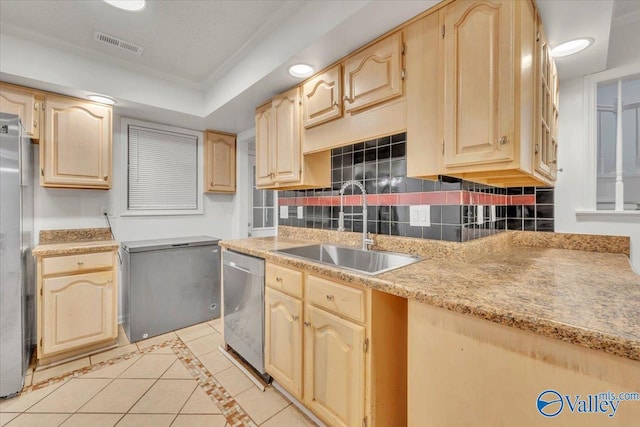 kitchen with light brown cabinetry, backsplash, stainless steel appliances, and a sink