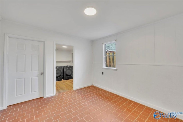 empty room featuring brick floor, baseboards, and washing machine and clothes dryer