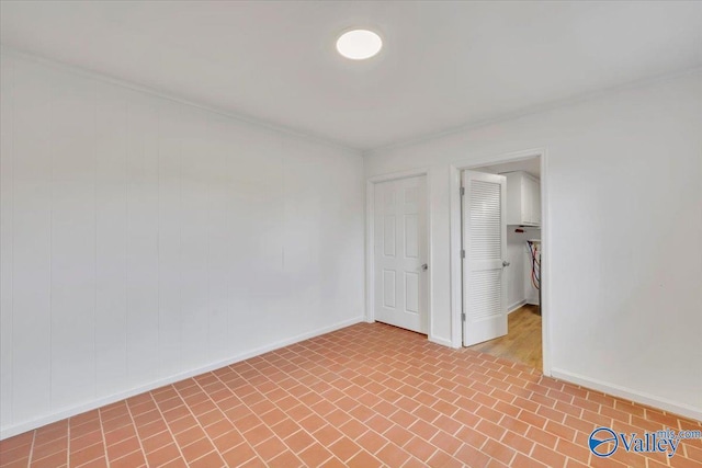 empty room featuring brick floor and baseboards