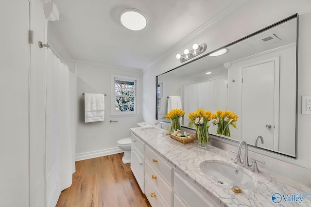 full bathroom featuring ornamental molding, wood finished floors, toilet, and a sink