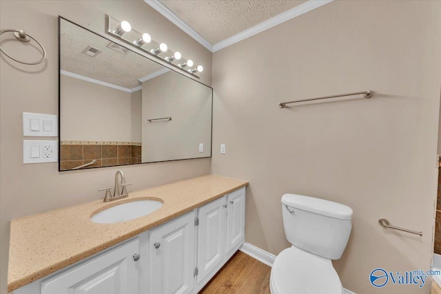 bathroom with vanity, wood finished floors, a textured ceiling, crown molding, and toilet