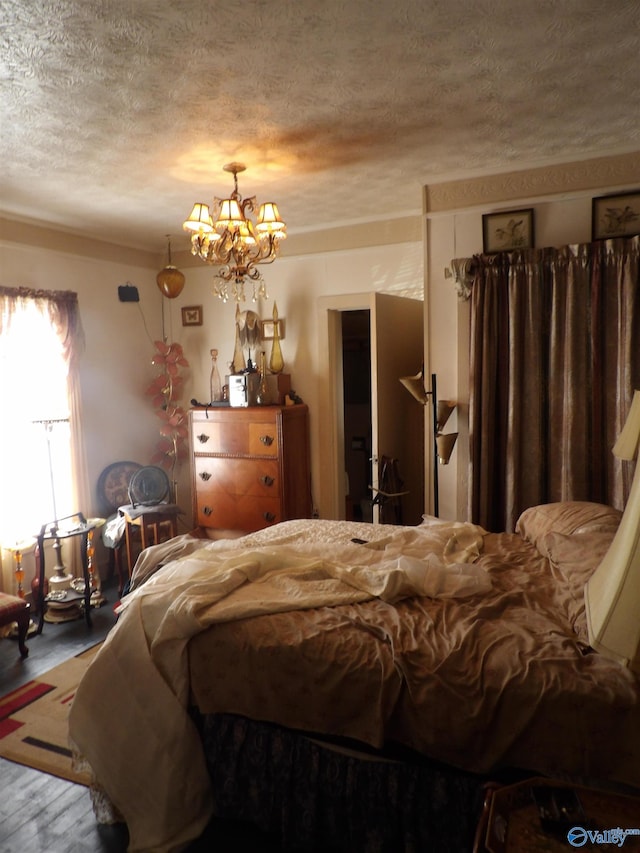 bedroom with a textured ceiling and an inviting chandelier