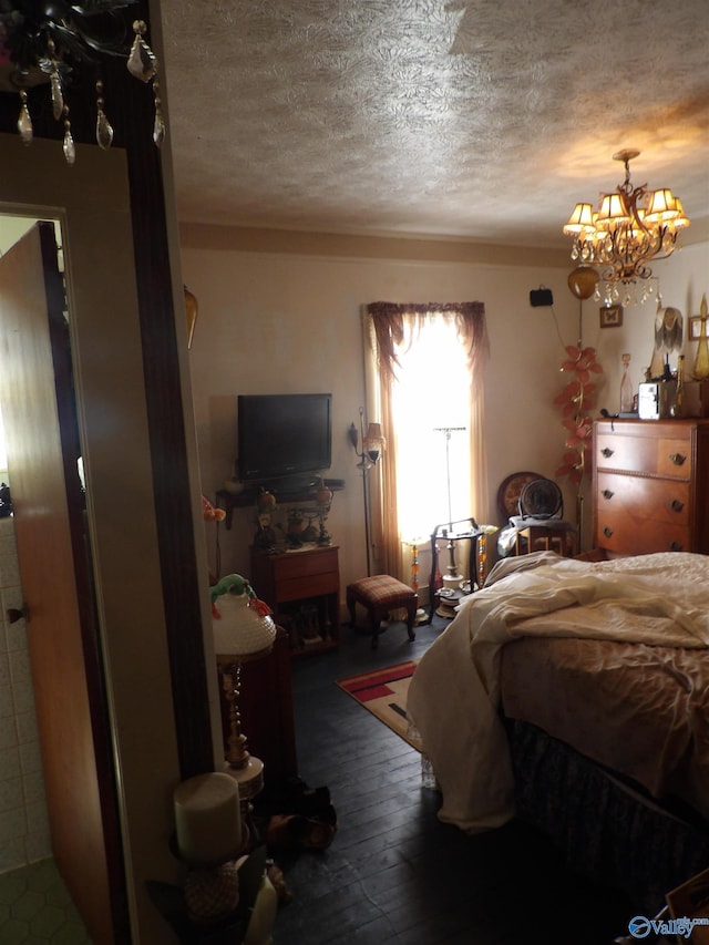 bedroom featuring a notable chandelier, a textured ceiling, and dark hardwood / wood-style flooring