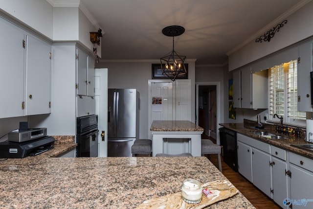 815 Sherman St SE, Decatur, AL 35601 - kitchen featuring black appliances, a sink, dark wood finished floors, crown molding, and hanging light fixtures