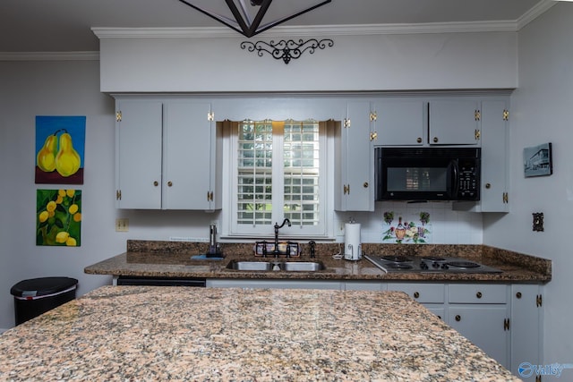 815 Sherman St SE, Decatur, AL 35601 - kitchen with black microwave, a sink, crown molding, stainless steel electric cooktop, and dark stone counters