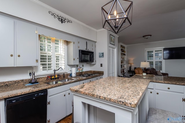 815 Sherman St SE, Decatur, AL 35601 - kitchen with black appliances, a sink, a chandelier, open floor plan, and crown molding