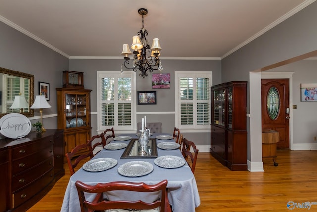 815 Sherman St SE, Decatur, AL 35601 - dining area featuring a chandelier, light wood-style flooring, healthy amount of natural light, ornamental molding, and baseboards
