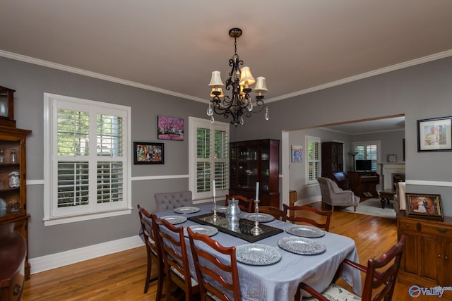 dining area featuring an inviting chandelier, hardwood / wood-style flooring, and crown molding