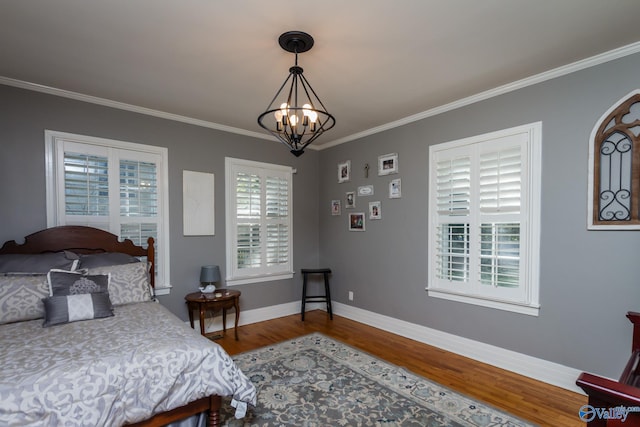 815 Sherman St SE, Decatur, AL 35601 - bedroom with a chandelier, wood finished floors, ornamental molding, and baseboards