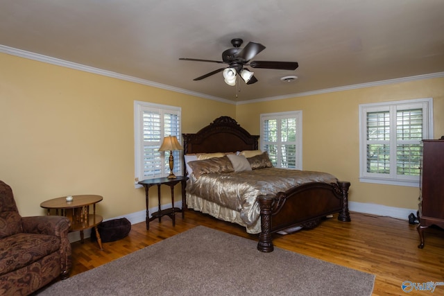 bedroom with ornamental molding, wood-type flooring, and ceiling fan