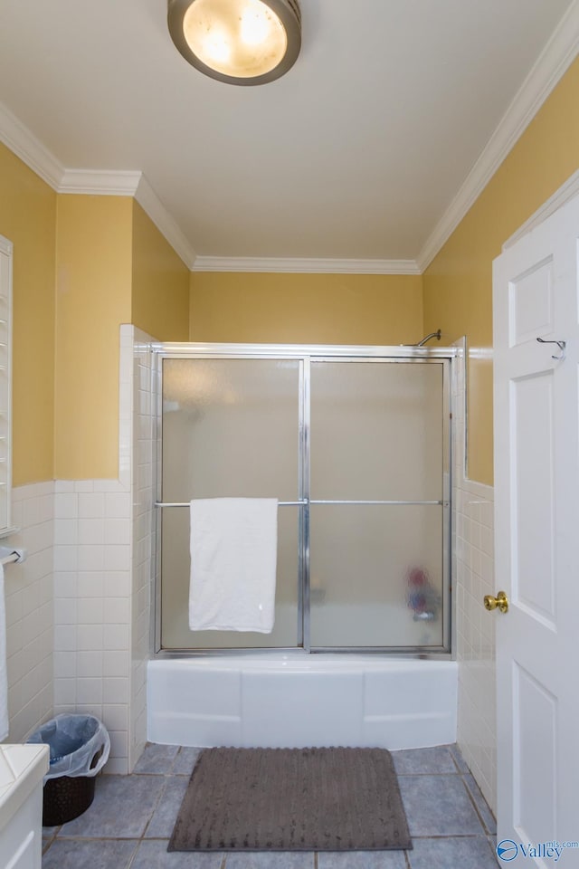 815 Sherman St SE, Decatur, AL 35601 - bathroom with tile walls, ornamental molding, combined bath / shower with glass door, tile patterned flooring, and wainscoting