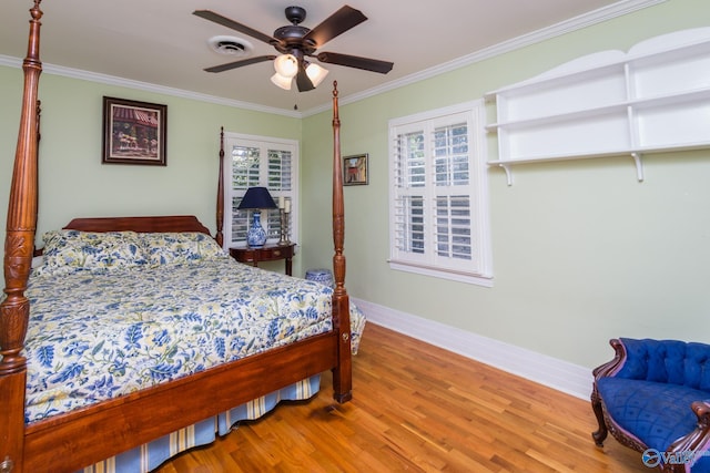 bedroom with ceiling fan, crown molding, and wood-type flooring