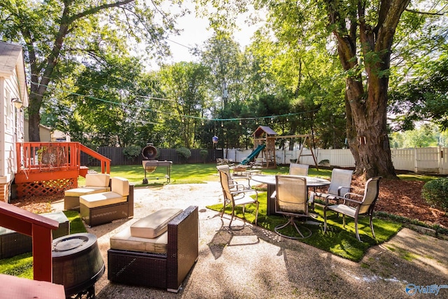 view of patio / terrace with a deck, a playground, and an outdoor fire pit