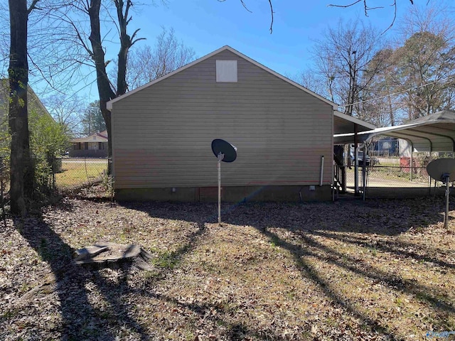 view of home's exterior featuring a carport and fence