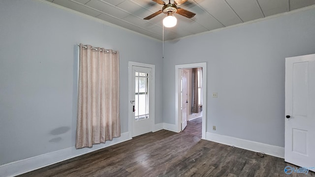 empty room featuring crown molding, dark wood-type flooring, and ceiling fan