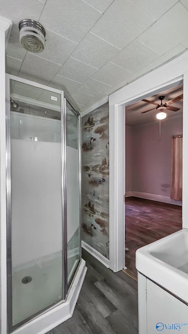 bathroom with wood-type flooring, a shower with shower door, ceiling fan, and vaulted ceiling