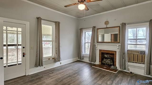 interior space with crown molding, ceiling fan, a fireplace, and dark wood-type flooring