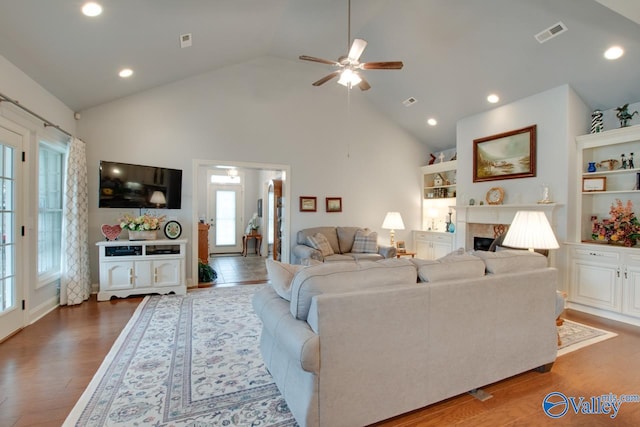 living room featuring hardwood / wood-style flooring, high vaulted ceiling, and ceiling fan