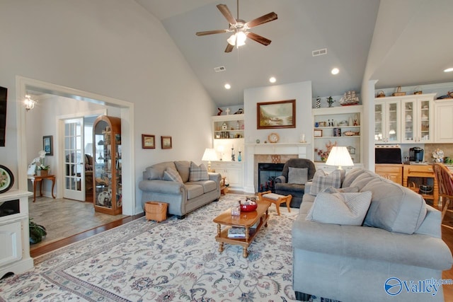 living room featuring light hardwood / wood-style flooring, high vaulted ceiling, and ceiling fan