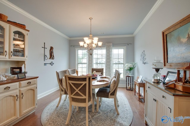 dining area featuring a chandelier, crown molding, and light hardwood / wood-style floors