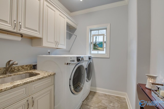 laundry area featuring crown molding, washer and clothes dryer, light tile patterned floors, cabinets, and sink