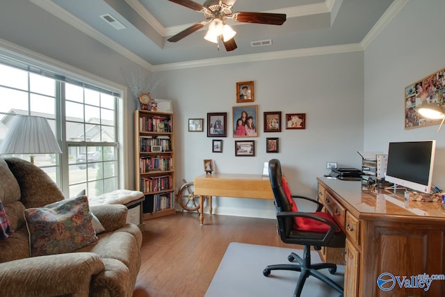 home office featuring ceiling fan, crown molding, a tray ceiling, and hardwood / wood-style floors