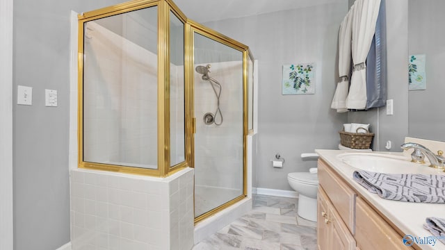 bathroom featuring toilet, a shower with door, and vanity