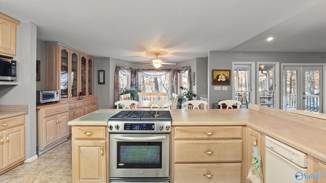 kitchen with stainless steel appliances, a wealth of natural light, ceiling fan, and light brown cabinets