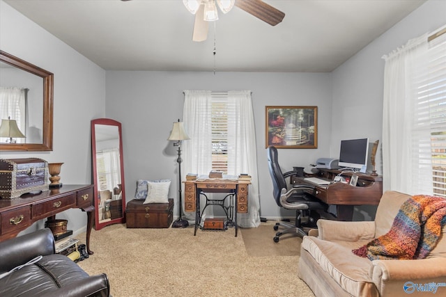 carpeted home office with ceiling fan and baseboards