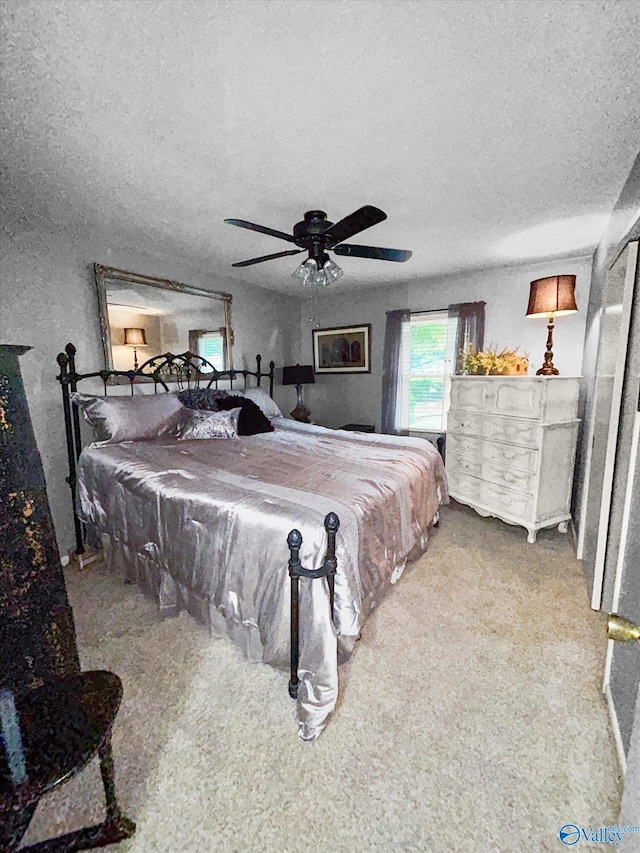 bedroom with a ceiling fan and a textured ceiling