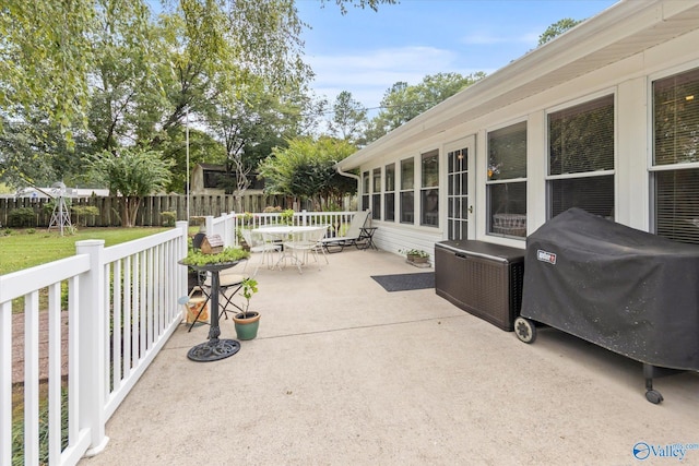 view of patio / terrace with outdoor dining area, a grill, and fence