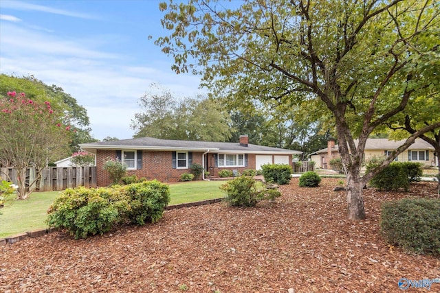 ranch-style home with an attached garage, brick siding, fence, a chimney, and a front yard