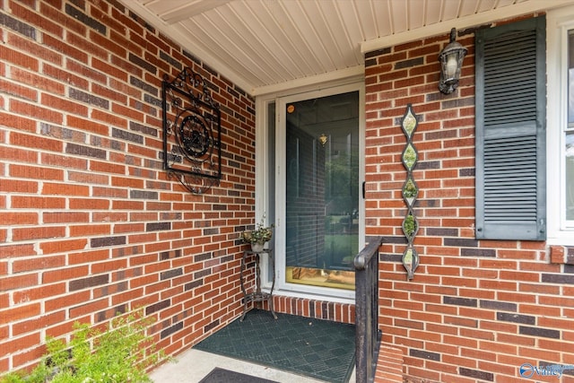 doorway to property featuring brick siding